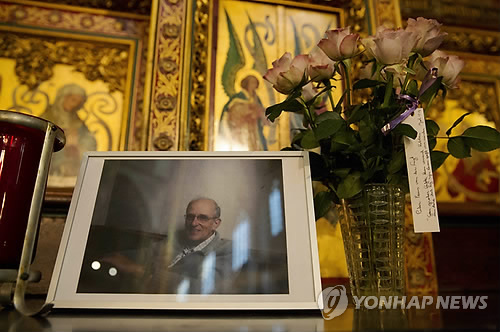 시리아에서 2014년 살해된 네덜란드 출신 예수회 사제 프란스 판데르 뤼흐트 신부의 사진이 놓인 암스테르담의 한 교회      [EPA=연합뉴스 자료사진]