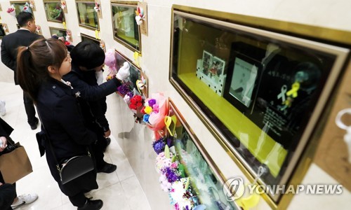 '너를 잊을 수 있을까'(인천=연합뉴스) 김인철 기자 = 세월호 참사 5주기인 16일 오전 인천시 부평구 인천가족공원 내 세월호 일반인 희생자 추모관에서 유가족들이 봉안함을 어루만지고 있다.