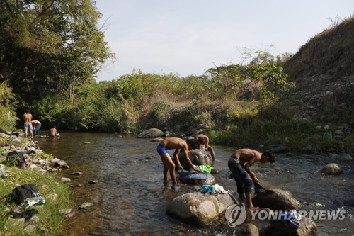 개울에서 목욕하고 빨래하는 중미 이민자들 [AP=연합뉴스]