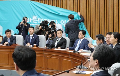 위기의 바른미래당(서울=연합뉴스) 이진욱 기자 = 23일 국회에서 열린 바른미래당 의원총회에서 당직자들이 떨어진 현수막을 바로 세우고 있다.