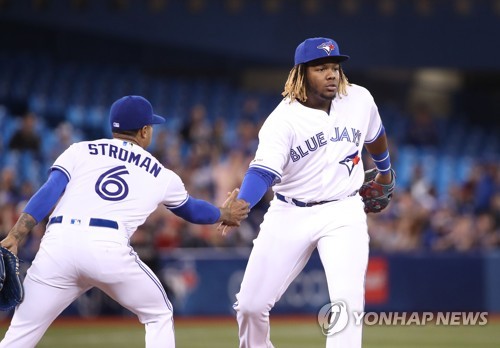 호수비 후 투수 스트로먼과 손바닥 부딪힌 게레로 주니어 [게티이미지/AFP=연합뉴스]