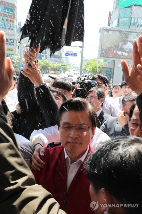 물세례 받는 황교안(광주=연합뉴스) 김주형 기자 = 자유한국당 황교안 대표를 비롯한 의원들이 3일 오전 광주광역시 송정역 광장에서 열린 '문재인 STOP! 광주시민이 심판합니다' 행사를 마친 뒤, 시민 단체들의 거센 항의를 받으며 역사로 이동하고 있다. 2019.5.3 kjhpress@yna.co.kr