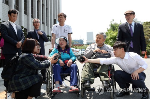 5·18 헬기사격 목격담 전하는 증언자들(광주=연합뉴스) 정회성 기자 = 5·18 민주화운동 당시 계엄군 총탄에 맞아 다친 남현애·이광영 씨가 13일 오후 광주지방법원에서 열린 '전두환 회고록 재판'에 증인으로 출석하며 기자들에게 헬기사격 목격담을 증언하고 있다. 2019.5.13 hs@yna.co.kr