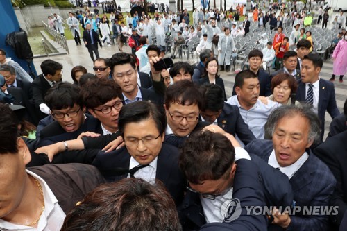 황교안 5·18기념식 참석 항의하는 시민(광주=연합뉴스) 정회성 기자 = 18일 오전 광주 북구 국립 5·18민주묘지에서 열린 제39주년 5·18민주화운동 기념식에 참석하는 자유한국당 황교안 대표 뒤쪽에서 일부 시민이 '망언 의원' 징계 등을 요구하며 항의하고 있다. 2019.5.18 hs@yna.co.kr