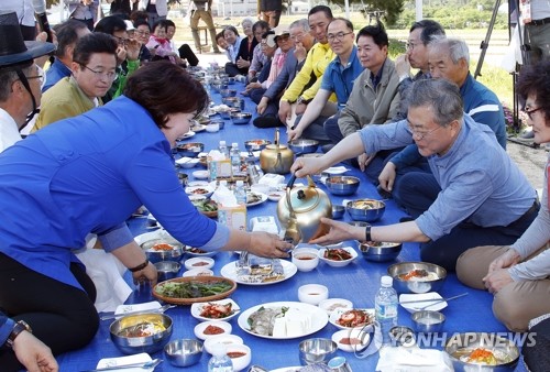 문 대통령, '한 잔 드세요'(경주=연합뉴스) 배재만 기자 = 문재인 대통령이 24일 오전 경북 경주시 옥산마을을 방문, 모내기를 마친 뒤 주민들과 새참을 함께하고 있다. 2019.5.24 scoop@yna.co.kr