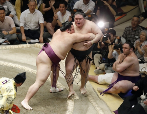 (도쿄 교도=연합뉴스) 아사노야마가 고에이도 선수를 요리키리 기술로 도효 밖으로 밀어내고 있다.