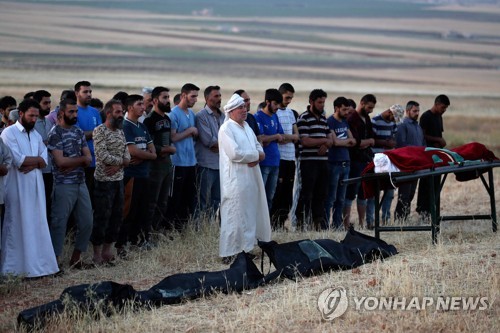 28일 카프르 할랍에서 공습으로 숨진 희생자의 시신을 앞에 두고 기도하는 시리아인들   [AFP=연합뉴스]