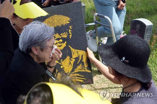 작품으로 승화된 고(故) 서유진 선생(광주=연합뉴스) 천정인 기자 = 1일 광주 북구 5·18구묘역(민족민주열사묘역)에서 열린 '5·18전도사' 고(故) 서유진 전 아시아인권위원회 특별대사의 안장식에서 서 전 대사의 부인 편남점 여사가 남편의 모습이 담긴 추모 작품을 전달받고 눈물을 흘리고 있다. 2019.6.1 iny@yna.co.kr