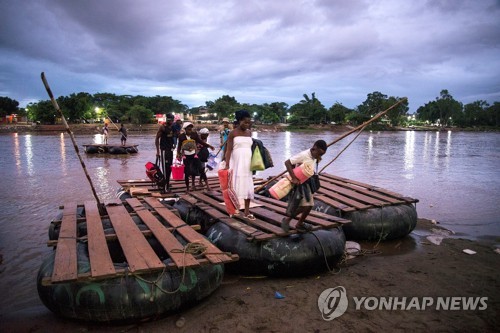 뗏목을 타고 멕시코 남부 국경 강을 건너는 아프리카 출신 이민자들 [EPA=연합뉴스]