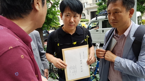 (도쿄=연합뉴스) 박세진 특파원 = 일제 징용 피해자 관련 소송을 지원하는 이상갑 법무법인 공감 대표변호사(오른쪽에서 2번째)가 20일 미쓰비시중공업 측에 전달할 대법원판결 후속 교섭 요청서를 들어 보이고 있다. 이 변호사는 미쓰비시 측의 건물 내 출입 불허로 직접 전달하지는 못했다. parksj@yna.co.kr