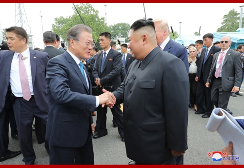 악수하며 대화하는 남북정상(서울=연합뉴스) 김정은 북한 국무위원장과 도널드 트럼프 미 대통령은 판문점 회동에서 교착 상태인 북미 대화를 재개하기로 합의했다고 조선중앙통신이 1일 보도했다. 중앙통신 홈페이지에 공개된 사진으로 김정은 위원장과 문재인 대통령이 악수하며 이야기 나누는 모습. 2019.7.1