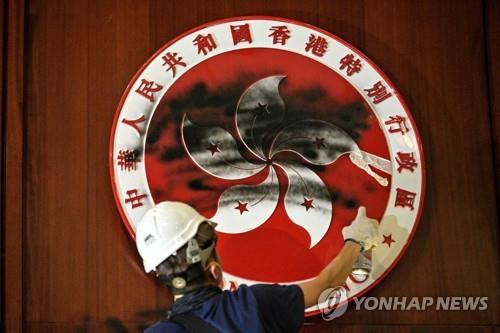 입법회 홍콩 상징물에 검은 물감 뿌리는 시위대[AFP=연합뉴스]