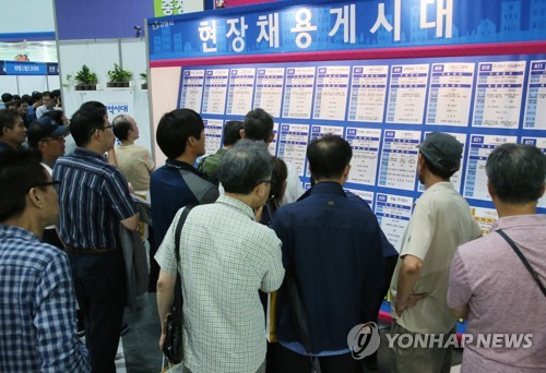 중장년 구직자들이 현장채용게시대를 살펴보고 있는 모습  [연합뉴스 자료사진]