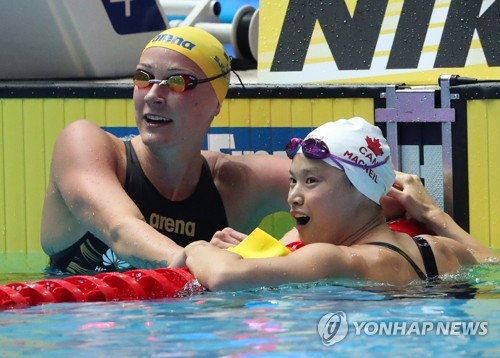 셰스트룀 4연패 저지한 맥닐(광주=연합뉴스) 양지웅 기자 = 22일 광주광역시 광산구 남부대 시립국제수영장에서 열린 2019 광주세계수영선수권대회 경영 여자 접영 100m 결승에서 우승을 차지한 캐나다의 마거릿 맥닐(오른쪽)이 2위로 들어온 스웨덴의 사라 셰스트룀과 기록을 확인하고 있다. 2019.7.22 yanagdoo@yna.co.kr