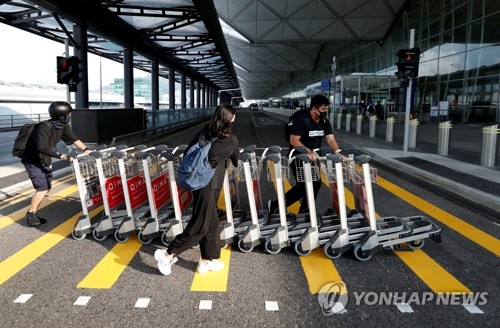 '바리케이드'로 쓸 카트 밀고가는 홍콩공항 시위대(홍콩 로이터=연합뉴스) 13일 홍콩 국제공항에서 반정부 시위대가 바리케이드로 쓰기 위해 승객용 손수레들을 출국장 안으로 끌어가고 있다. bulls@yna.co.kr