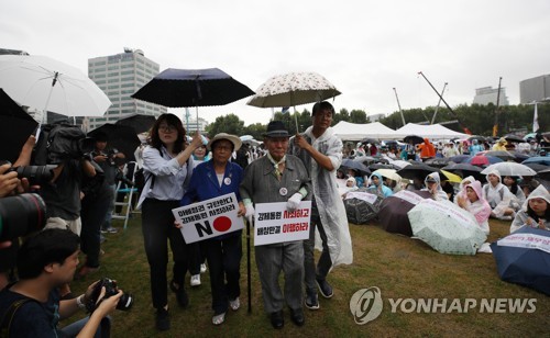 무대 오르는 이춘식 할아버지와 양금덕 할머니(서울=연합뉴스) 박동주 기자 = 15일 서울광장에서 열린 일제 강제동원 문제 해결을 위한 시민대회에서 강제징용 피해자 이춘식 할아버지와 양금덕 할머니가 무대에 오르고 있다. 2019.8.15 pdj6635@yna.co.kr
