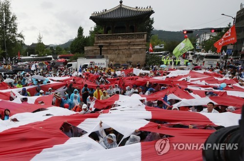 일본대사관 앞에서 찢어지는 욱일기(서울=연합뉴스) 김주성 기자 = 광복절인 15일 8·15 전국 노동자 대회 참가자 등 일본 아베 정부를 규탄하는 시민들이 서울 종로구 일본대사관 앞에서 전범기인 욱일기를 찢는 퍼포먼스를 하고 있다. 2019.8.15 utzza@yna.co.kr