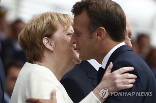 지난달 14일 파리 샹젤리제 거리에서 열린 프랑스 대혁명 기념일 행사에서 만나 포옹하는 독일의 앙겔라 메르켈 총리와 프랑스의 에마뉘엘 마크롱 대통령(오른쪽) [EPA=연합뉴스 자료사진]