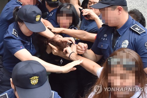 머리채 잡힌 고유정(제주=연합뉴스) 전 남편 살해 혐의로 구속기소 된 고유정이 12일 오전 제주지법에서 첫 재판을 받고 나와 호송차에 오르기 전 한 시민에게 머리채를 잡히고 있다. 2019.8.12 jihopark@yna.co.kr
