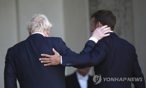 22일 파리 엘리제궁서 기자회견 뒤 서로의 등을 두드리는 보리스 존슨 영국 총리와 에마뉘엘 마크롱 프랑스 대통령(오른쪽) [AP=연합뉴스]