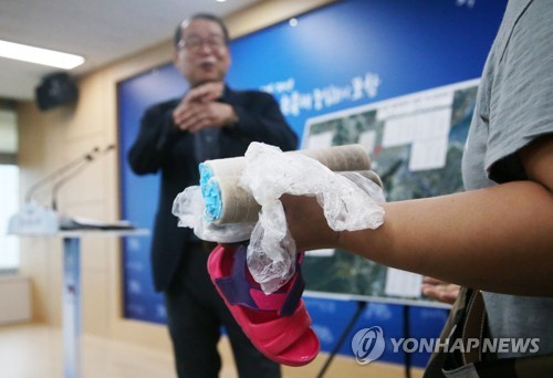 질문하는 포항시민(포항=연합뉴스) 손대성 기자 = 22일 경북 포항시청에서 '포항 수돗물 필터 변색 관련 민간 전문조사단' 단장인 서정인 영남대 교수에게 한 시민이 단시간에 급속도로 색이 변한 필터를 들고 질문하고 있다. 2019.8.22 sds123@yna.co.kr