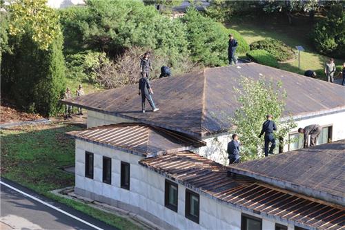 JSA내 건물 지붕 보수 공사 중인 북한 작업 인력[유엔군사령부 페이스북 캡처]