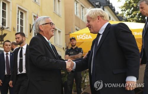 악수하는 장클로드 융커 EU 집행위원장(왼쪽)과 보리스 존슨 영국 총리 [AP=연합뉴스]