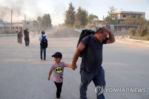 지난 10일(현지시간) 터키의 침공에 시리아 북부 고향을 등지는 쿠르드 가족[EPA=연합뉴스]