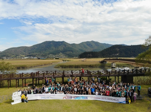 17일 순천만습지를 찾은 한아세안 인사들이 습지를 배경으로 기념사진을 찍고 있다 [한-아세안센터 제공]