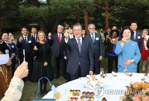 주한외교단 초청 리셉션, 건배 대신 'K-하트'(서울=연합뉴스) 한상균 기자 = 문재인 대통령이 18일 오후 청와대 녹지원에서 주한외교단 초청 리셉션에서 참석자들과 함께 손가락 하트를 하고 있다. xyz@yna.co.kr