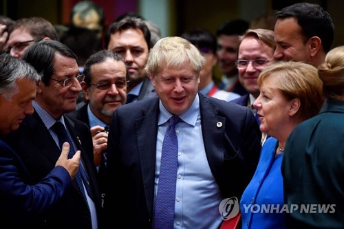 보리스 존슨 영국 총리(가운데)가 17일(현지시간) EU 정상회의에서 앙겔라 메르켈 독일 총리 등 EU 정상들과 이야기를 나누고 있다. [AFP=연합뉴스]