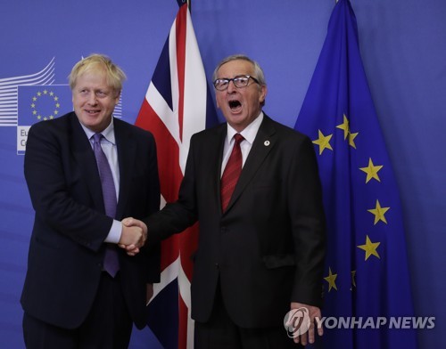 보리스 존슨 영국 총리(왼쪽)와 장클로드 융커 EU 집행위원장이 17일(현지시간) 벨기에 브뤼셀 EU 본부에서 기자회견을 준비하며 악수하고 있다. [EPA=연합뉴스]