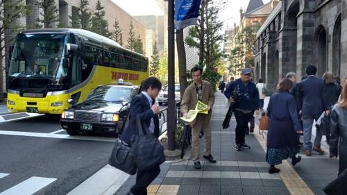 '일본제철 구(舊) 징용공 재판을 지원하는 모임' 회원인 엔도 쓰토무 씨가 30일 도쿄 지요다(千代田)구 마루노우치(丸ノ內) 일본제철 본사 앞에서 한국 대법원의 징용 피해자 배상 판결을 이행하라고 촉구하는 내용의 유인물을 나눠주고 있다.
