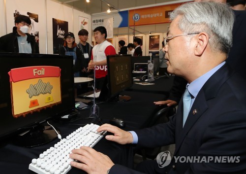'게임은 어려워' 전시 체험하는 김용삼 차관(서울=연합뉴스) 이재희 기자 = 29일 오전 서울 강남구 코엑스에서 열린 '2019 글로벌 게임 챌린지'(GGC) 전시를 찾은 김용삼 문화체육관광부 1차관이 학생들이 만든 게임을 체험하고 있다. 2019.10.29 scape@yna.co.kr