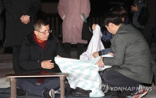 담요 덮는 황교안(서울=연합뉴스) 신준희 기자 = 3일째 단식 중인 자유한국당 황교안 대표가 22일 오후 청와대 앞 분수대 광장에서 강기정 청와대 정무수석에게 지소미아 효력정지 연기 관련 설명을 들은 후 담요를 덮고 있다. 2019.11.22 hama@yna.co.kr