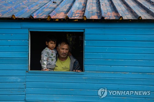 그리스 레스보스섬 내 한 난민캠프에 거주하는 아프가니스탄 출신 부자의 모습. [AFP=연합뉴스]