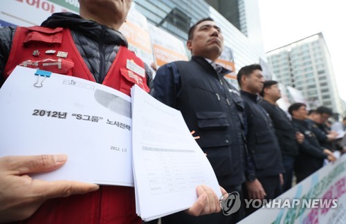 'S그룹 노사전략 문건'지난해 서울 서초구 삼성전자 사옥 앞에서 열린 삼성그룹 계열사의 노조타압 규탄 및 무노조 경영폐기 촉구 기자회견에서 한 조합원이 2012년S그룹 노사전략 문건을 들고 있다. [연합뉴스 자료사진]