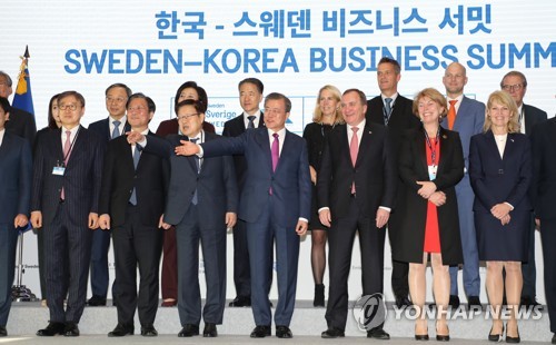 기념촬영하는 한-스웨덴 정상(서울=연합뉴스) 한상균 기자 = 문재인 대통령과 스테판 뢰벤 스웨덴 총리가 18일 오후 송파구 롯데타워에서 한-스웨덴 비즈니스 서밋 참석자들과 기념촬영을 하고 있다. 2019.12.18 xyz@yna.co.kr