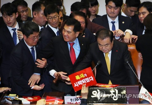 거세게 항의하는 심재철(서울=연합뉴스) 진성철 기자 = '공직선거법 개정안'이 통과된 27일 국회 본회의에서 문희상 국회의장이 의사봉을 두드리는 동안 자유한국당 심재철 원내대표가 거세게 항의하다 제지당하고 있다.   2019.12.27 zjin@yna.co.kr