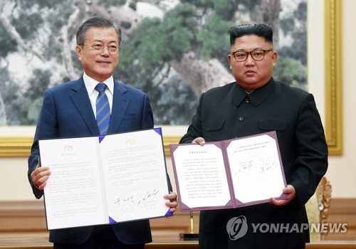 문재인 대통령과 김정은 국무위원장이 2018년 9월 19일 오전 평양 백화원 영빈관에서 평양공동선언문에 서명한 후 합의서를 들어보이고 있다. [연합뉴스 자료사진]