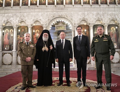 7일 다마스쿠스에 있는 그리스정교회 예배당 찾은 푸틴 러시아 대통령(가운데)과 아사드 시리아 대통령(오른쪽 두번째)   [타스=연합뉴스]