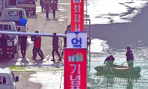 화천산천어축제장 복구(화천=연합뉴스) 9일 강원 화천군 산천어축제장이 최근 내린 겨울 폭우로 침수되자 축제 관계자들이 떠내려온 부유물 제거작업 등을 벌이고 있다.  2020.1.9  [화천군 제공.재판매 및 DB 금지] hak@yna.co.kr