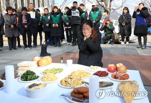 슬픈 설날   (서울=연합뉴스) 한종찬 기자 = 25일 서울 세종로 소공원 앞에서 열린 故 문중원 열사, 톨게이트 수납원 노동자 합동차례에서 문중원 기수 부인 오은주씨가 차례를 지내고 있다. 2020.1.25 saba@yna.co.kr