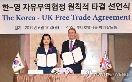 한-영 FTA 원칙적 타결 유명희 산업통상자원부 통상교섭본부장과 리암 폭스 영국 국제통상부 장관이 지난해 6월 10일 서울 중구 롯데호텔에서 '한-영 자유무역협정(FTA) 원칙적 타결 선언식에서 공동합의문에 서명한 뒤 기념촬영을 하고 있다. [연합뉴스 자료사진]