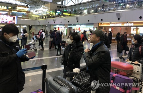 마스크 쓴 베이징 공항 승객들(베이징=연합뉴스) 김윤구 특파원 = 2일 중국 베이징 서우두공항에서 한 승객이 출국장 앞에서 잠시 마스크를 벗고 신분 확인을 하고 있다. 2020.2.2 ykim@yna.co.kr