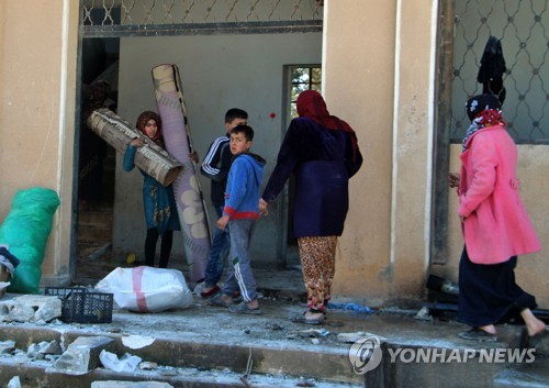 3일(현지시간) 시리아 이들립 지역에서 이주민들이 정부군의 공습을 받은 학교를 돌아다니는 모습. [AFP=연합뉴스]