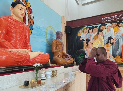 (아산=연합뉴스) 이희용 기자 = 담마끼띠 스님이 석가모니불을 향해 스리랑카식으로 합장 배례하고 있다. 오른쪽은 목련존자상이다.