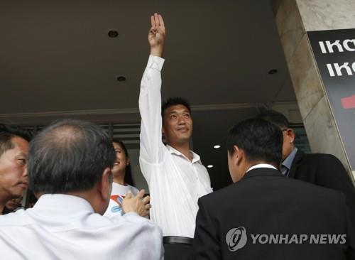 경찰서에 도착해 지지자들을 향해 '세 손가락' 표시'를 하는 타나톤 대표. 2019.4.6[AP=연합뉴스]