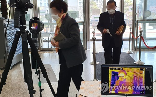 예배 전 열 체크 필수(춘천=연합뉴스) 양지웅 기자 = 8일 오전 강원 춘천시의 한 교회에서 주일 예배에 참석하는 신도들이 열 화상 감지기 앞을 지나가고 있다. 2020.3.8 yangdoo@yna.co.kr