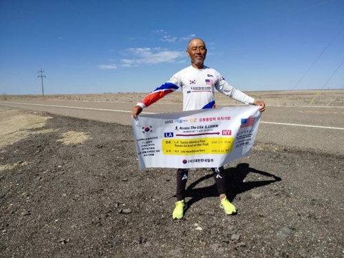 '2032년 서울평양공동 올림픽 유치기원' 플래카드를 들고 2032km 지점에서 기념촬영[진장환 사이트 캡처]